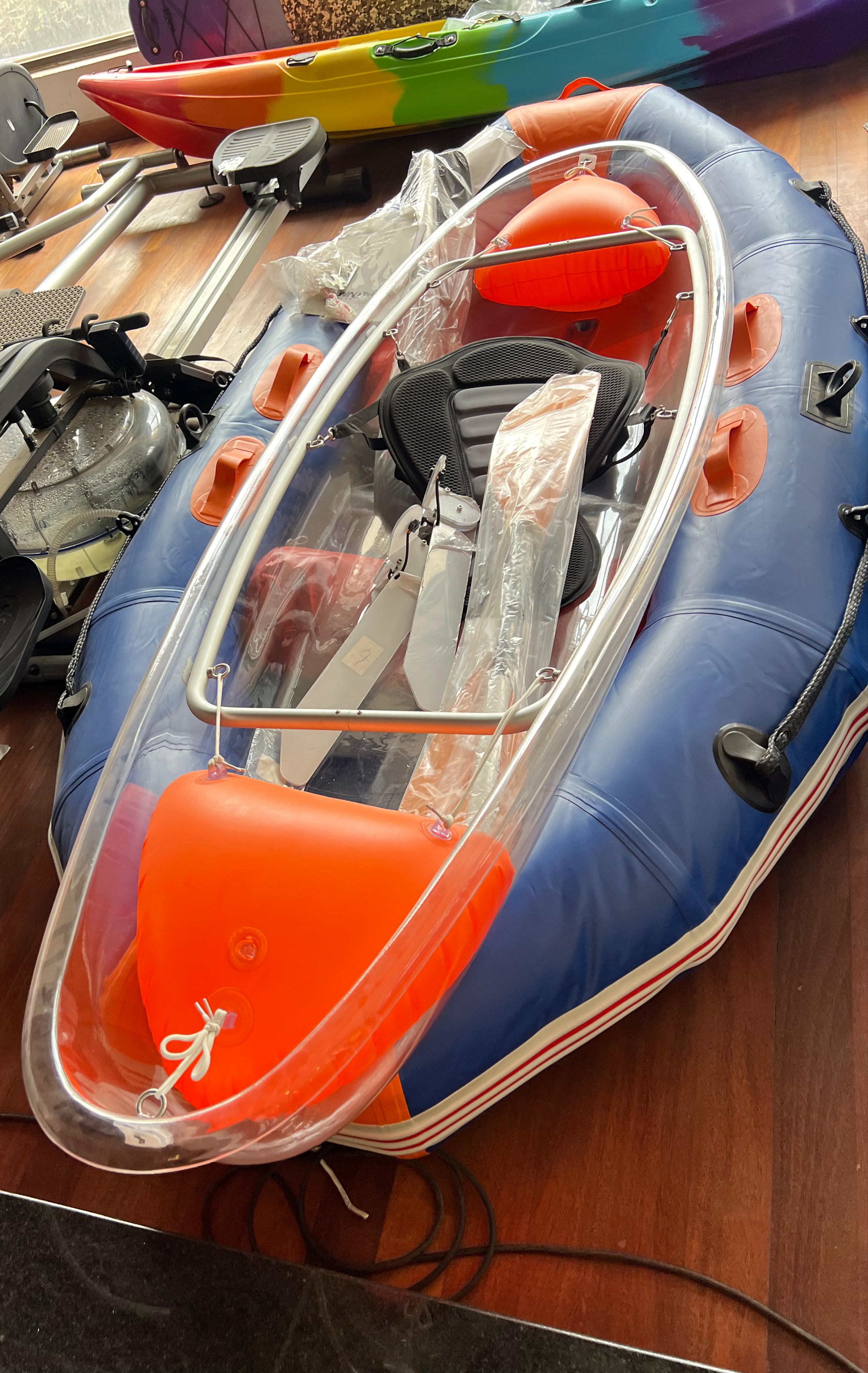 Clear kayak with one black seat and paddle